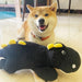 Dog playing with a toy alligator on a tiled floor